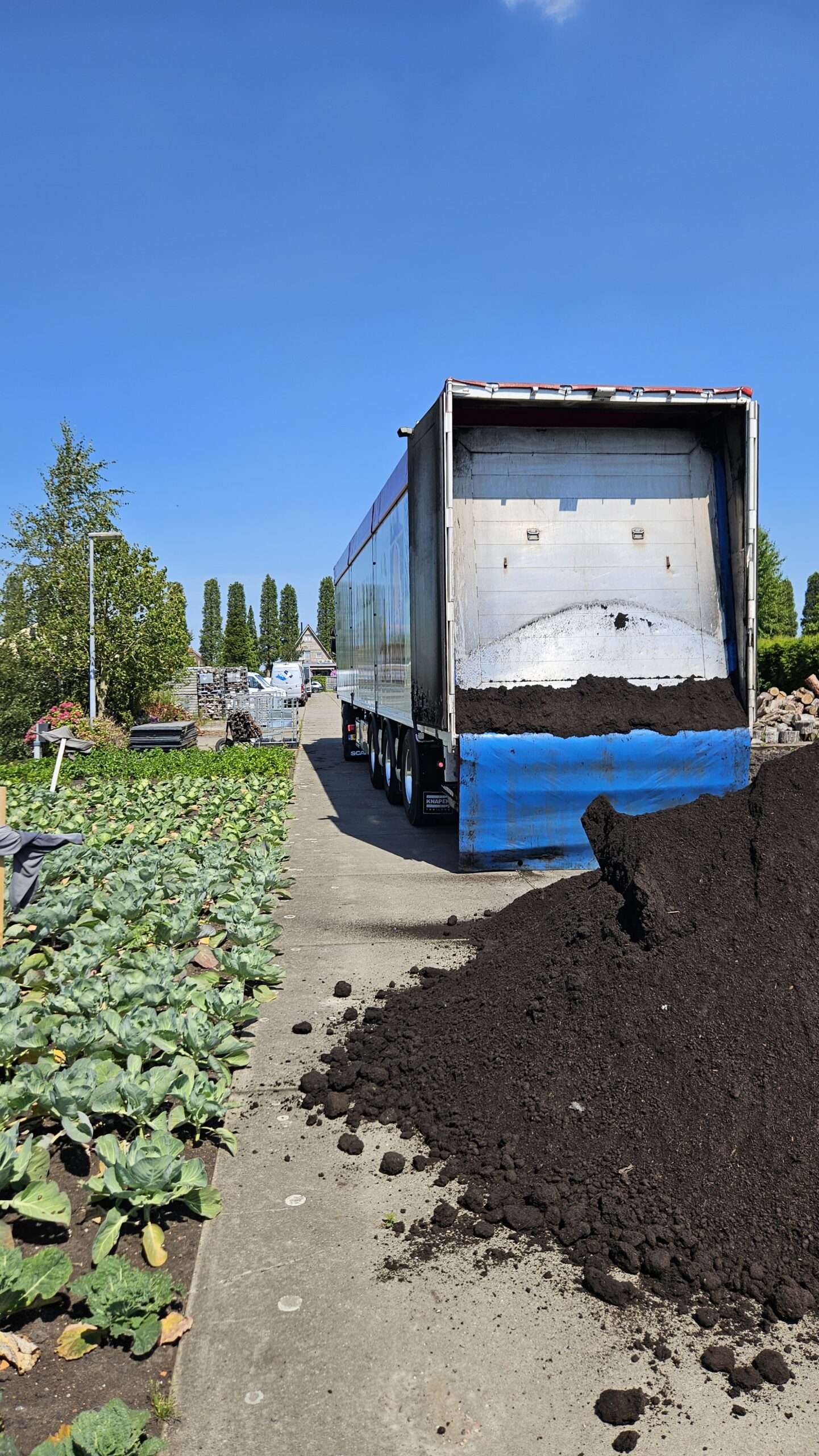 De Pokon vrachtwagen die 55m3 grond komt brengen voor het aanhelen van de moestuin